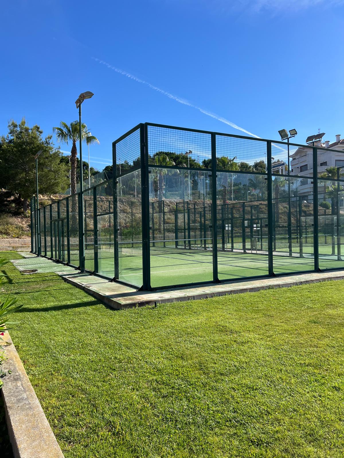 Detail van een padelcourt naast het mediterrane groen